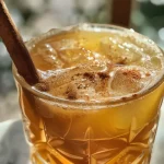 Close-up view of a fresh Apple Cider Mocktail with spices.
