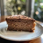 Close-up side view of a Chai Protein Cake topped with cream cheese frosting.