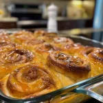 Close-up view of a cinnamon roll casserole shaped like brains, with red food coloring accents.