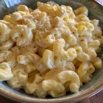 Close-up view of creamy cottage cheese mac n cheese with melted cheddar on top.