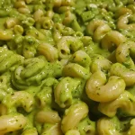 A close-up side view of green slime spinach mac and cheese in a bowl.