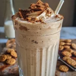 Close-up of a creamy gingerbread milkshake topped with whipped cream and gingersnap crumbs.