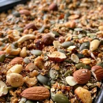 Close-up view of grain-free granola with nuts and seeds on a wooden table.