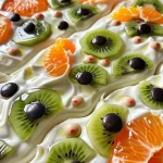 Close-up view of Halloween Monster Yogurt Bark decorated with colorful fruits and candy eyes.