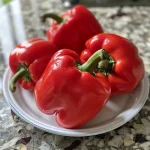 Close-up view of vibrant red bell peppers, showcasing their juicy texture for homemade smoked paprika.