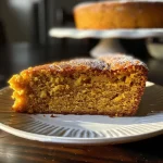 Close-up side view of a moist pumpkin cake with a golden-brown crust.