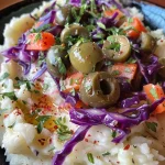 Close-up of a colorful Monster Mash dish featuring mashed potatoes, red cabbage, olives, and shredded carrots.