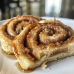 Close-up view of a gooey protein cinnamon roll drizzled with icing.