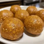 Close-up of golden-brown pumpkin protein balls with a textured surface.