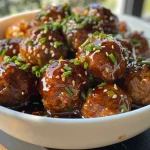 Close-up view of succulent meatballs coated in a glossy maple glaze.