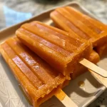 Close-up view of a colorful Sweet Potato Paleta with a smooth texture and vibrant orange hue.