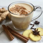 Close-up of Vanilla Oolong Chai with spices and milk in a clear glass.