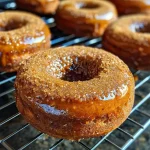 Close-up view of a glazed vegan gingerbread donut with sprinkles of gingerbread sugar.