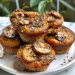 Close-up side view of vegan mushroom muffins with a golden-brown crust and visible chunks of mushrooms.